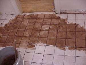 Spread grout over tiles